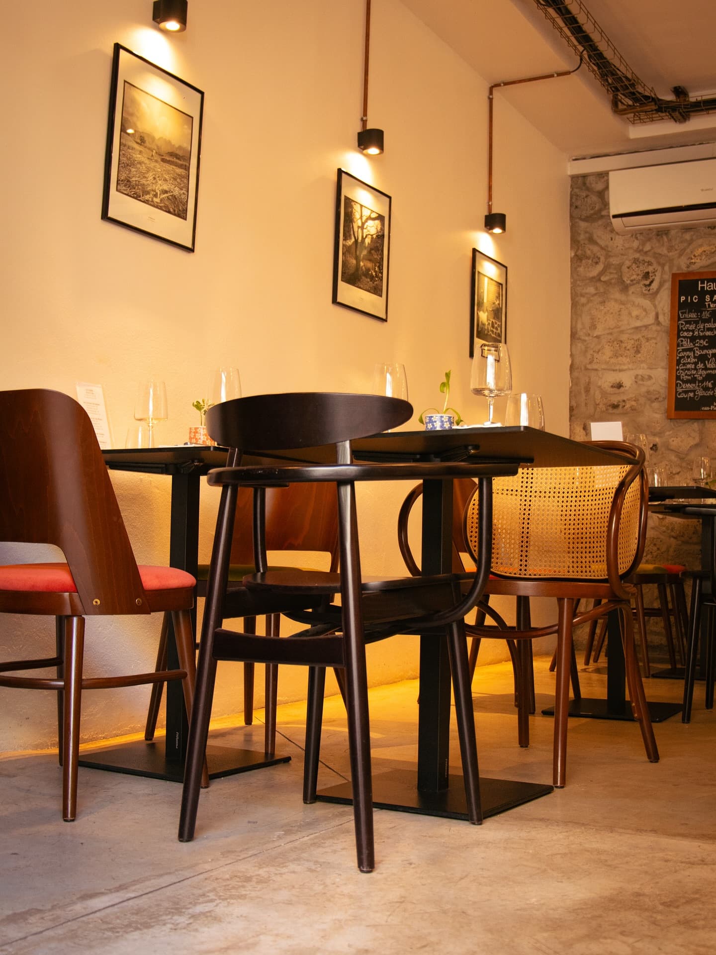 La salle du Vieux Comptoir : appliques cuivrées, cadres et chaises bistrot dans une lumière chaude